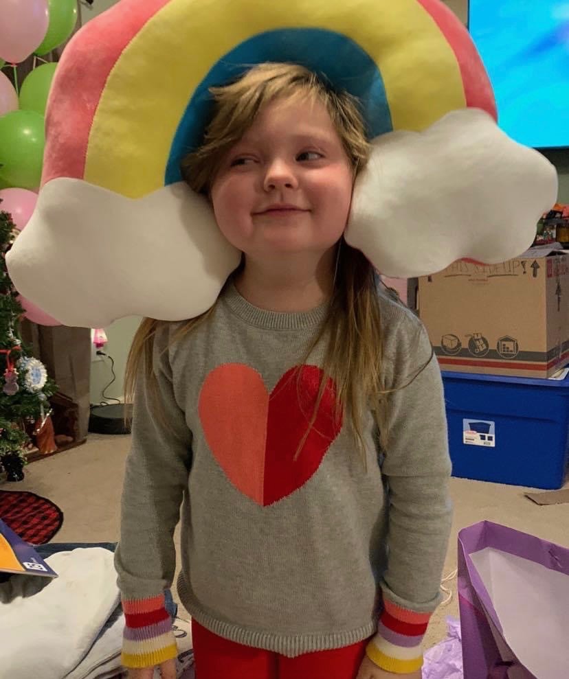 Kenzie Scoggins, 5, poses with a rainbow pillow. Kenzie's mother, Meghan Scoggins, described her as 'rainbows and sunshine and sass.'
